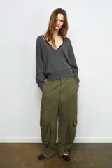 Jersey de punto liso color rojo, con escote en V profundo y mangas largas. Presenta terminaciones en rib en el cuello, puños y ruedo.