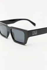 Lentes de sol negros con marco rectangular y lentes grises.