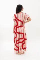 Vestido largo tipo remerón con estampado a rayas verticales en tonos beige, rosa y rojo. Presenta escote redondo y volados rojos en forma de espiral.