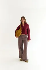 Camisa de corte boxy color bordó, con cuello clásico, cierre frontal de botones y mangas largas con detalle de tablas en los puños. Presenta costuras a contratono y frunce en la espalda.