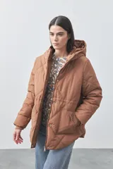 Campera puffer negra con diseño acolchado, capucha integrada y cierre frontal con botones a presión. Presenta puños elásticos y costuras decorativas en el frente.