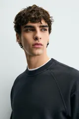 Sudadera regular fit color azul, de cuello redondo, manga larga ranglán y efecto lavado con acabados en rib.