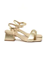 Sandalias de cuero dorado metalizado con tira ancha delantera, pulsera delicada ajustable al tobillo y tacón bloque.