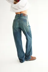 Jean negro de corte recto con recortes laterales, roturas en bolsillos, pespuntes a contratono y zigzag característico de la marca BG.