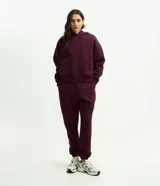 Pantalón jogger de corte holgado, color bordó, con cintura elástica, bolsillos laterales y puños ajustados en los tobillos.