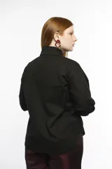 Camisa oversize de manga larga en color blanco, confeccionada en algodón. Presenta cuello clásico, puños abotonados y una abertura central ovalada con jaretas ajustables que permiten fruncir la prenda.