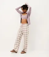 Pantalón de pijama Lov de corte holgado, confeccionado en franela de algodón. Presenta un estampado de cuadros en tonos beige y blanco, con cintura elástica y cordón de ajuste frontal.