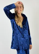 Blazer gris de terciopelo con solapas y cierre frontal con un botón. Presenta un patrón de matices sutiles en la tela.