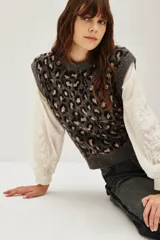 Chaleco de punto con diseño de animal print de leopardo en tonos grises y negros, con cuello redondo y corte sin mangas.