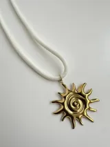 Collar de cuerda blanca con dije colgante en forma de sol con diseño en espiral, hecho en acero quirúrgico dorado.