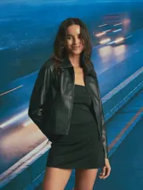 Chaqueta de cuero sintético color negro, con cuello clásico, cierre frontal con cremallera y diseño de corte recto.
