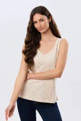 Musculosa de algodón color beige con delicado estampado floreado, escote redondo y pequeños volados en las sisas.