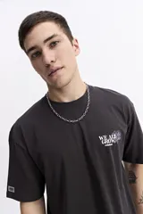 Remera de manga corta color crema con cuello redondo y fit regular. Presenta un estampado grande en la espalda con una flor estilizada en tonos rojo y azul, y texto que incluye "WE ALL GROW" y "trust the process, great things take time".