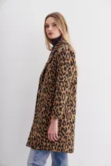 Tapado de corte recto con solapas angostas, cierre frontal con botones y bolsillos ojal. Confeccionado en paño con estampado animal print.