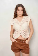 Chaleco color crudo de tejido calado, con escote en V, cierre frontal de botones y mangas cortas con volados.