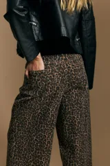 Pantalón de tiro medio con corte recto y silueta amplia, confeccionado en tejido con estampado animal print de leopardo.