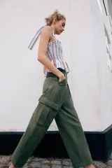 Pantalón cargo de tiro medio con pinzas delanteras, bolsillos laterales de plastrón y cierre frontal con cremallera y botón. Presenta una pernera holgada que se estrecha ligeramente hacia el bajo.