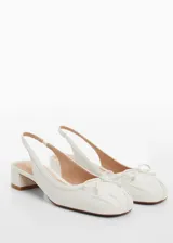 Zapato destalonado de efecto piel en color blanco, con punta redonda, lazo decorativo en el empeine y tacón bloque bajo.