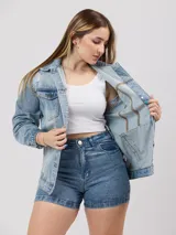 Campera de jean celeste con detalles de roturas, corte oversize, cuello clásico, cierre con botones metálicos, bolsillos frontales con solapa y puños abotonados.
