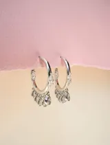 Aros tipo argolla dorados con siete circonias transparentes colgantes.