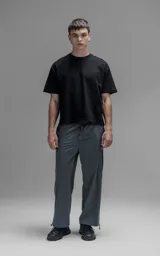 Pantalón de corte oversize color gris carbón, confeccionado en microfibra técnica. Presenta cintura elástica, bolsillos laterales, un bolsillo cargo con cierre de broche y sistema de elásticos con tancas en los tobillos para regular la apertura.