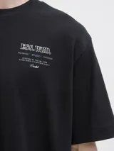 Remera básica de manga corta y color negro, con cuello redondo y diseño clásico para uso diario. Presenta un pequeño estampado tipográfico en el pecho.