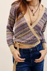 Cardigan cruzado de punto con estampado en zigzag en tonos lila, beige y negro, escote en V cruzado, mangas largas y lazo para atar en la cintura.