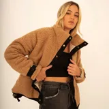 Campera puffer de corderito color tostado, con cuello alto, cierre frontal con botones a presión y detalles en color negro.
