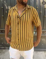 Camisa amarilla con rayas verticales negras, cuello americano y cierre frontal con botones.