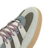 Championes adidas Handball Spezial con diseño retro, confeccionados en una combinación de gamuza y tejido acanalado. Presentan una paleta de colores en tonos gris claro, verde oliva y detalles en violeta, con la clásica suela de goma color caramelo.