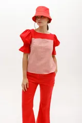 Blusa de mangas cortas abullonadas, con cuerpo a rayas horizontales rojas y blancas, y mangas y parte superior rojas.