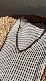 Vestido midi de punto acanalado, color beige con rayas verticales marrones, escote en V y abertura lateral.