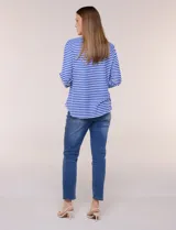 Remera de calce relajado y silueta fluida, con escote en V y mangas tres cuartos con presilla y botón. Diseño de rayas dispuestas en ángulo tipo espiga en el delantero y ruedo redondeado.