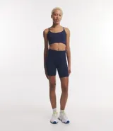 Bermuda deportiva de tiro alto con cintura ancha, confeccionada en tejido de poliamida y elastano. Diseño liso y ajustado, ideal para actividades físicas.
