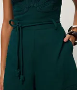 Short corto en viscolino verde oscuro, con cintura elástica, cordón ajustable con detalle de nudos y dobladillo pespuntado.