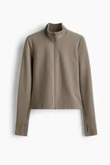 Campera deportiva corta de tejido funcional SoftMove™ en color marrón, con cuello elevado, cierre frontal y mangas largas con abertura para el pulgar.