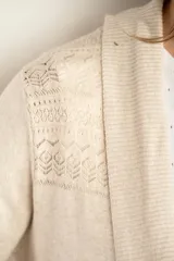 Cardigan color salmón de algodón y elastano, con solapa y lazo ajustable en la cintura.