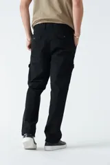 Pantalón cargo verde militar de gabardina, corte recto, con dos bolsillos laterales con fuelle y cierre de solapa, y logo bordado.