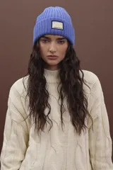 Gorro de punto fucsia con etiqueta de marca en el frente.