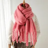 Bufanda de tejido suave y abrigado en color rosado, con diseño de textura esponjosa y flecos largos en los extremos.