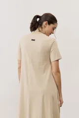 Vestido midi negro con diseño de manga corta, cuello redondo y bolsillos laterales, corte amplio y fluido.
