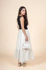 Falda larga color crudo, de silueta amplia con volado en el ruedo y cintura elástica.