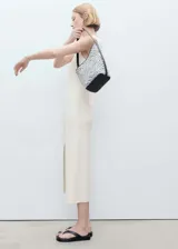 Vestido midi de tejido de punto fino, con diseño recto, cuello barco y sin mangas. Presenta una abertura lateral en el bajo.