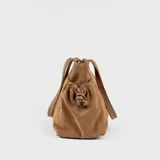 Bolso tipo tote bag color marrón camel, confeccionado en descarne vacuno gamuzado y cuero graneado. Tiene doble asa corta de hombro y correa larga extraíble. Presenta detalles fruncidos en los laterales, tres compartimentos interiores y dos bolsillos exteriores.