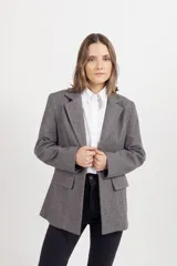Blazer de paño fantasía en color gris, con forro interior, solapas clásicas y dos bolsillos delanteros con solapa.