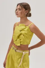 Pantalón sastrero de tiro alto color verde lima, confeccionado en tafeta metalizada, con calce holgado y pierna ancha.