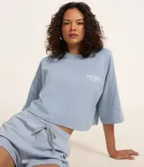 Remera corta celeste de algodón con estampado en la espalda con texto en blanco.