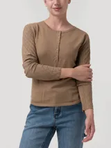 Remera de manga larga color tostado, con cuello redondo y cartera de botones frontal. Presenta detalles de tejido trenzado en las mangas.