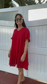 Vestido corto rojo con escote en V, mangas cortas con volados y corte escalonado.