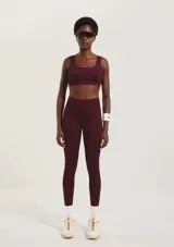 Calza deportiva de tiro alto con textura acanalada, color bordó, diseñada para brindar soporte y flexibilidad durante el entrenamiento.